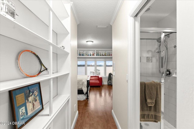 corridor featuring dark hardwood / wood-style floors, a textured ceiling, and crown molding