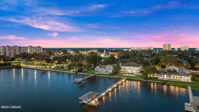 aerial view at dusk featuring a water view