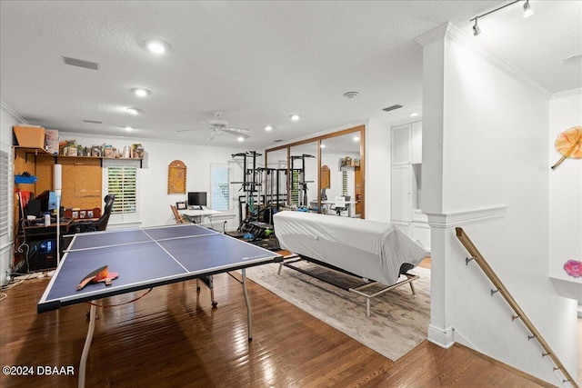 recreation room featuring ceiling fan, a textured ceiling, hardwood / wood-style flooring, and ornamental molding