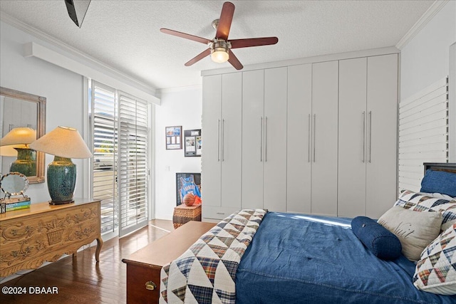 bedroom with ornamental molding, hardwood / wood-style floors, ceiling fan, and a textured ceiling