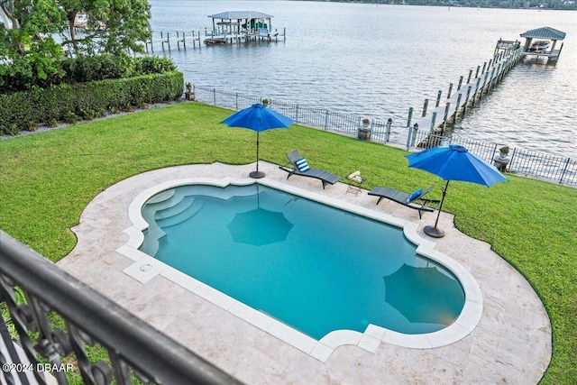 view of pool featuring a water view and a lawn