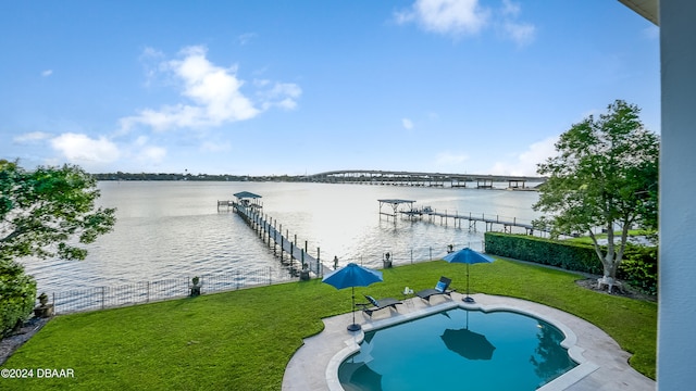 view of pool featuring a lawn, a water view, and a boat dock