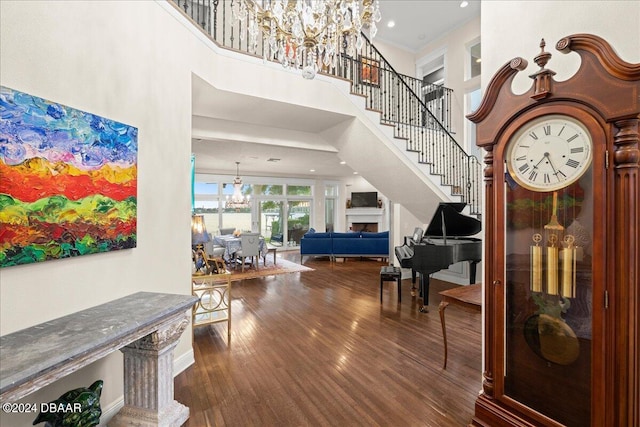 entryway with a high ceiling, wood-type flooring, and a chandelier