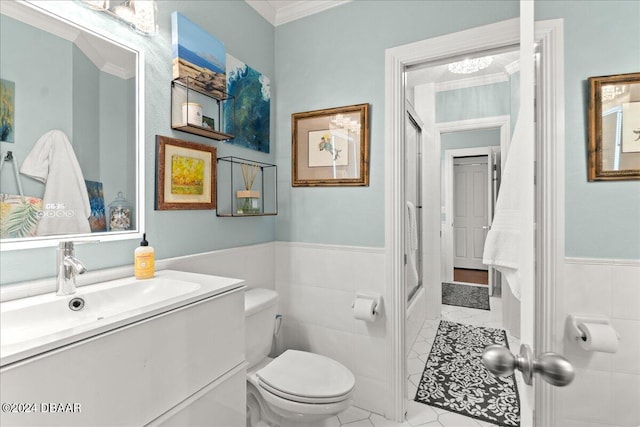 bathroom featuring ornamental molding, vanity, tile patterned floors, toilet, and tile walls