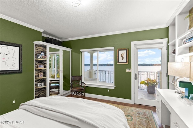 bedroom with a water view, multiple windows, light hardwood / wood-style floors, and access to exterior