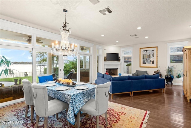 dining area with a textured ceiling, dark wood-type flooring, and a chandelier