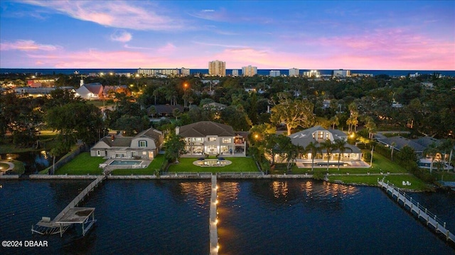 aerial view at dusk featuring a water view