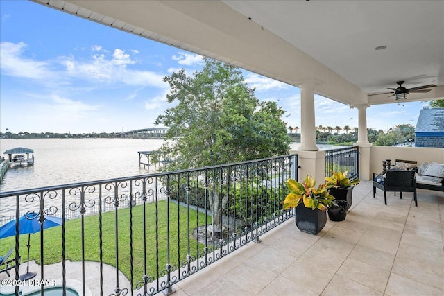 balcony featuring a water view and ceiling fan