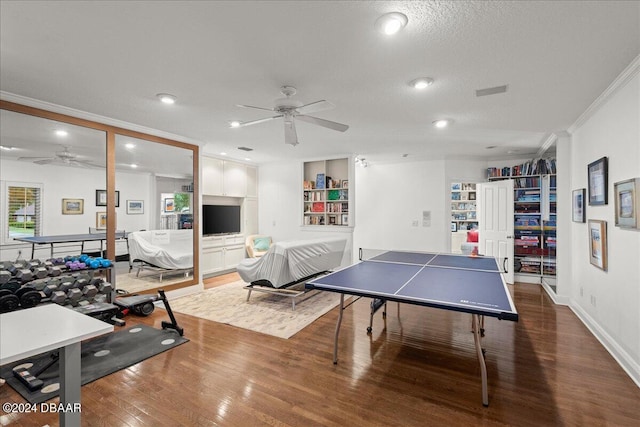 playroom with ceiling fan, hardwood / wood-style floors, crown molding, and a textured ceiling