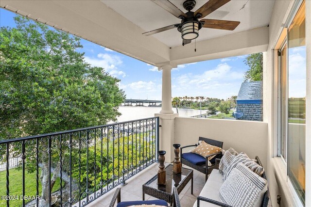 balcony with a water view and ceiling fan