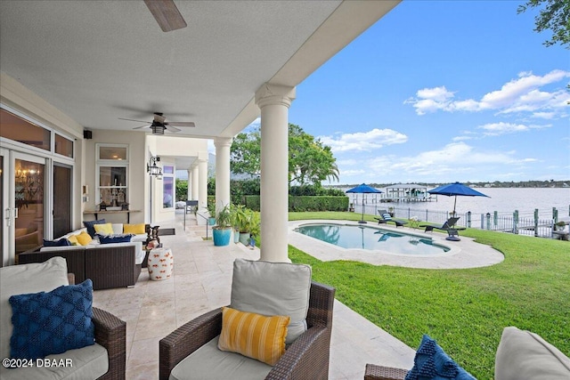 view of patio / terrace with a fenced in pool, an outdoor living space, a water view, and ceiling fan