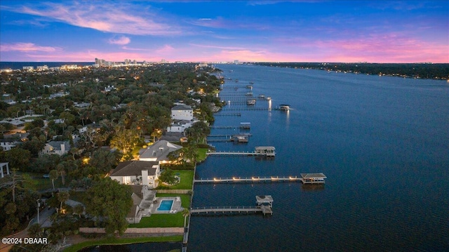 aerial view at dusk featuring a water view