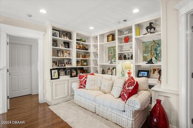 living area featuring hardwood / wood-style floors and crown molding