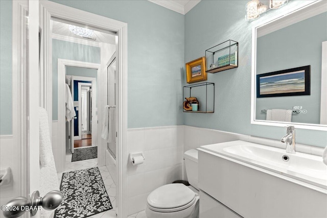 full bathroom with tile walls, tile patterned floors, crown molding, vanity, and toilet