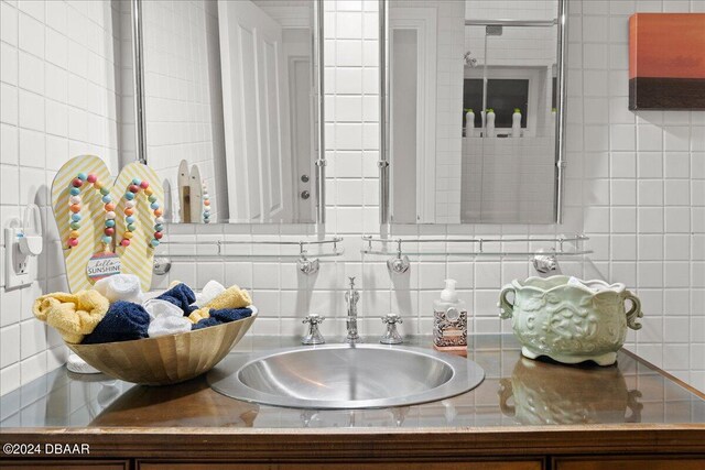 bathroom with tile walls, decorative backsplash, and vanity