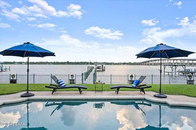 view of pool featuring a lawn and a water view