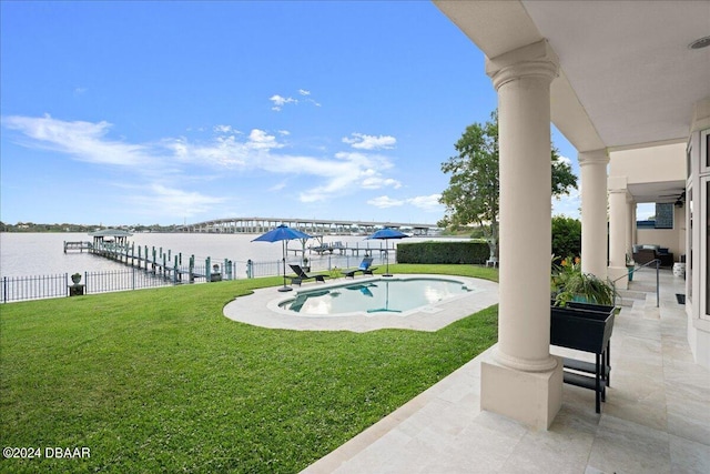 view of pool featuring a water view, a lawn, and a patio area