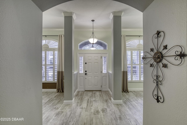 entrance foyer with light wood-type flooring, ornate columns, and ornamental molding