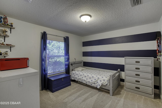 bedroom with light colored carpet and a textured ceiling