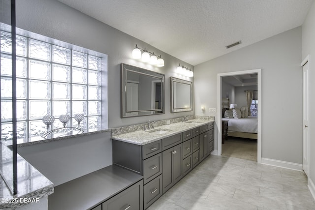 bathroom with vanity, a textured ceiling, and vaulted ceiling