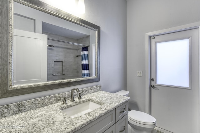 bathroom featuring walk in shower, vanity, and toilet