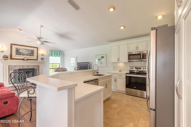 7 Fernery Trl, Ormond Beach, FL 32174 - kitchen featuring stainless steel appliances, a breakfast bar area, a sink, ceiling fan, and open floor plan