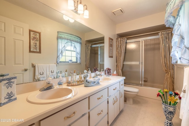 7 Fernery Trl, Ormond Beach, FL 32174 - bathroom with double vanity, tile patterned floors, bath / shower combo with glass door, and toilet
