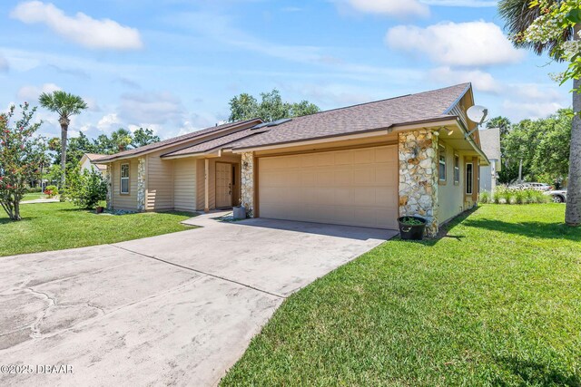 104 Herring Gull Ct, Daytona Beach, FL 32119 - view of front facade featuring an attached garage, stone siding, concrete driveway, and a front lawn