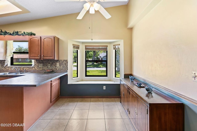 104 Herring Gull Ct, Daytona Beach, FL 32119 - kitchen featuring tasteful backsplash, light tile patterned floors, a peninsula, ceiling fan, and brown cabinets