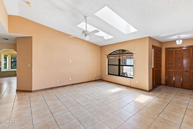 104 Herring Gull Ct, Daytona Beach, FL 32119 - spare room featuring a skylight, light tile patterned floors, lofted ceiling, a textured ceiling, and a smoke detector