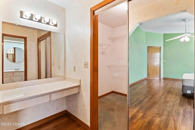 104 Herring Gull Ct, Daytona Beach, FL 32119 - bathroom with wood finished floors, ceiling fan, a textured ceiling, vanity, and wallpapered walls