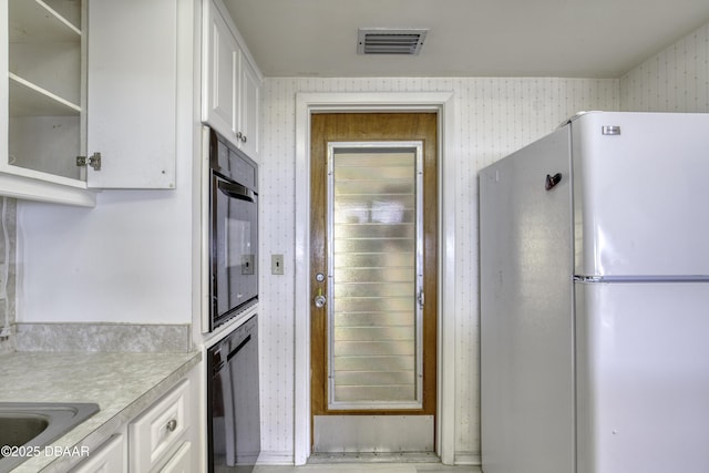 34 Kathy Dr, Ormond Beach, FL 32176 - kitchen featuring black appliances, wallpapered walls, white cabinets, and light countertops