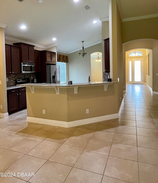 kitchen with stainless steel appliances, light tile patterned floors, and a breakfast bar