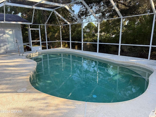 view of pool featuring glass enclosure and a patio