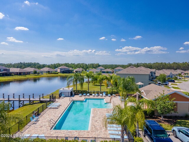 view of pool with a patio area and a water view