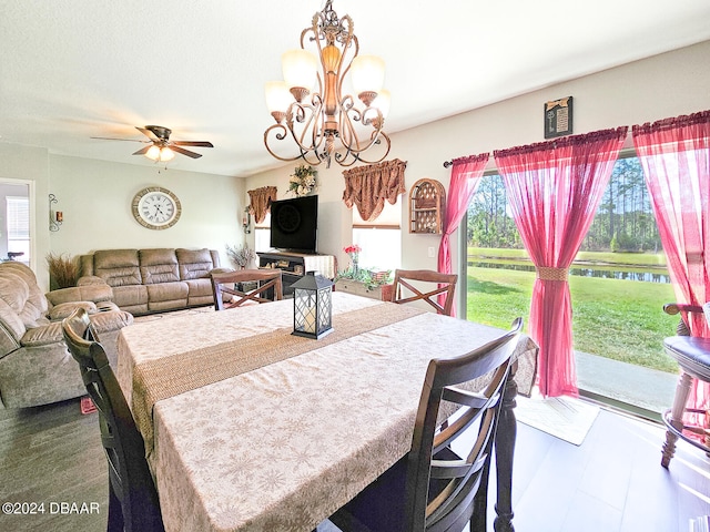 dining space featuring ceiling fan with notable chandelier