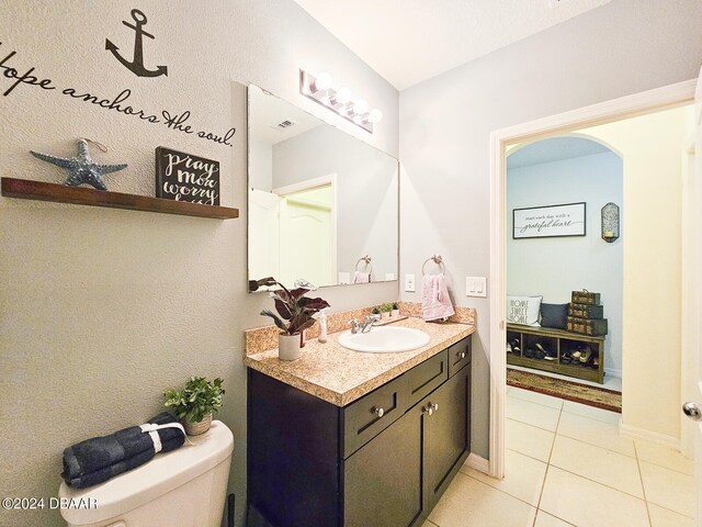 bathroom with toilet, vanity, tile patterned flooring, and ceiling fan