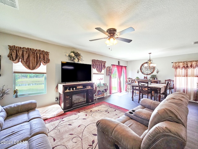 living room with wood-type flooring, ceiling fan, and a textured ceiling