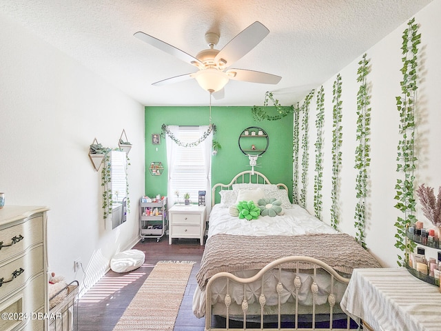 bedroom with a textured ceiling, dark hardwood / wood-style floors, and ceiling fan