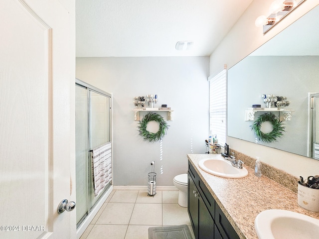 bathroom featuring toilet, an enclosed shower, vanity, and tile patterned floors