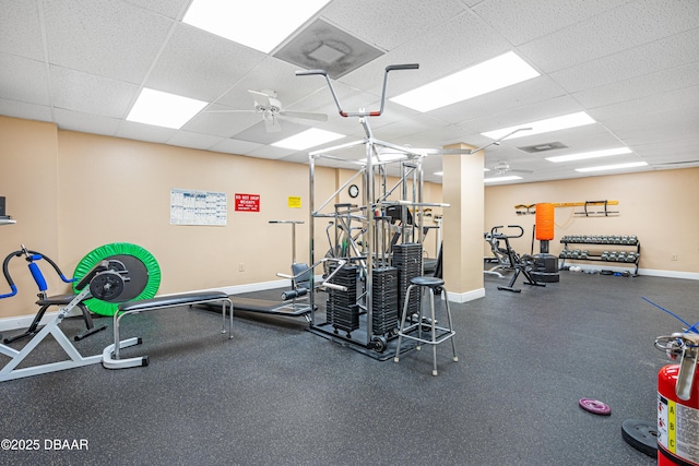 gym featuring a paneled ceiling and ceiling fan