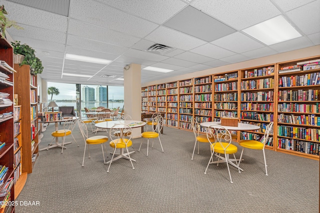 interior space with a paneled ceiling and a water view