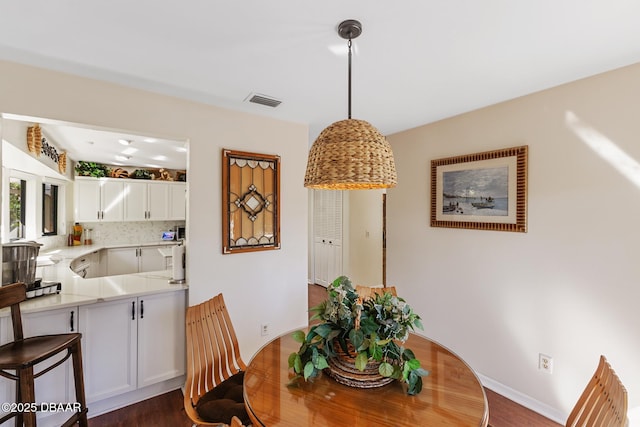 dining area featuring baseboards, visible vents, and dark wood-style flooring