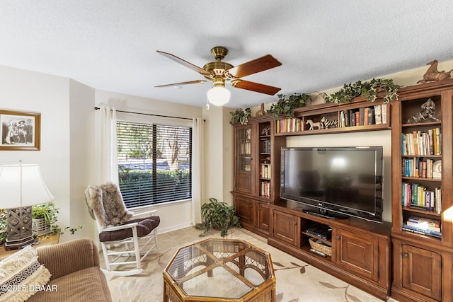 living room with a textured ceiling and ceiling fan