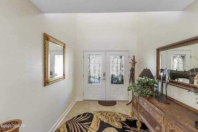 entryway with light tile patterned flooring, baseboards, and french doors