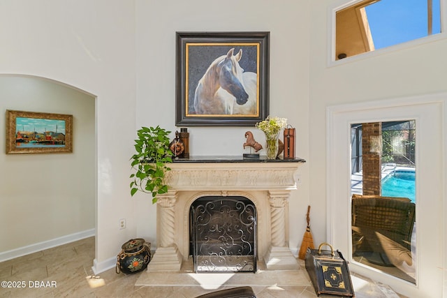 living room featuring a fireplace with flush hearth and baseboards