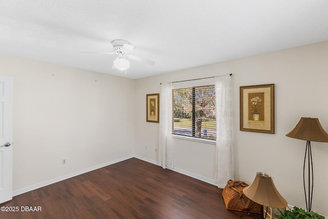 empty room with ceiling fan, baseboards, and wood finished floors