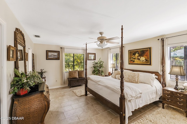 bedroom featuring a ceiling fan, multiple windows, visible vents, and baseboards