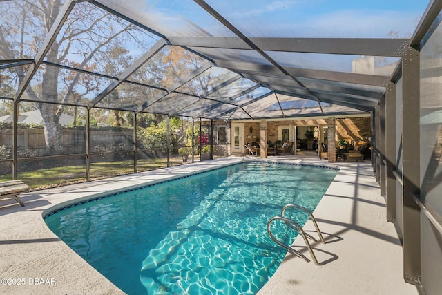 view of swimming pool with glass enclosure, a patio area, fence, and a fenced in pool