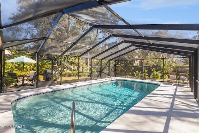 outdoor pool with glass enclosure and a patio